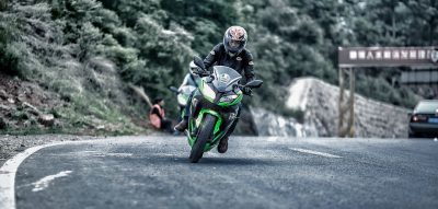 guy driving green and black motorcycle