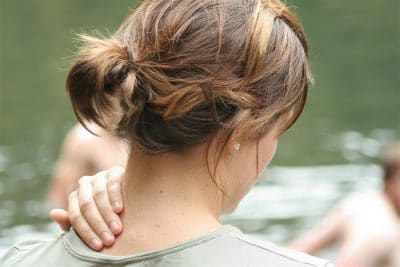woman massaging her neck due to a neck injury