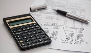 calculator and pen with financial paperwork