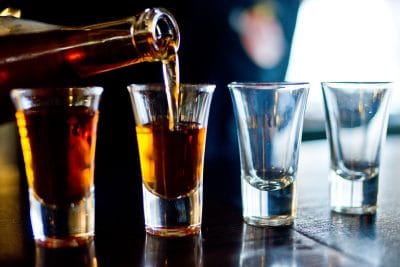 alcohol being poured into shot glasses