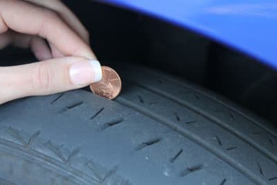 A penny inserted into a tire tread