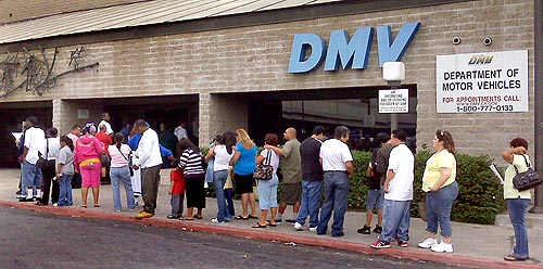 A line of people waiting outside a DMV office.