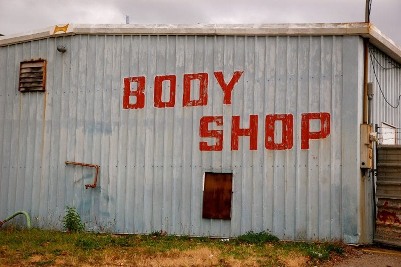 Aluminum building with words: "Body Shop" on the side.