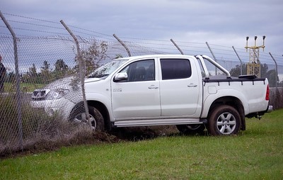 White pickup truck crashed into chainlink fence