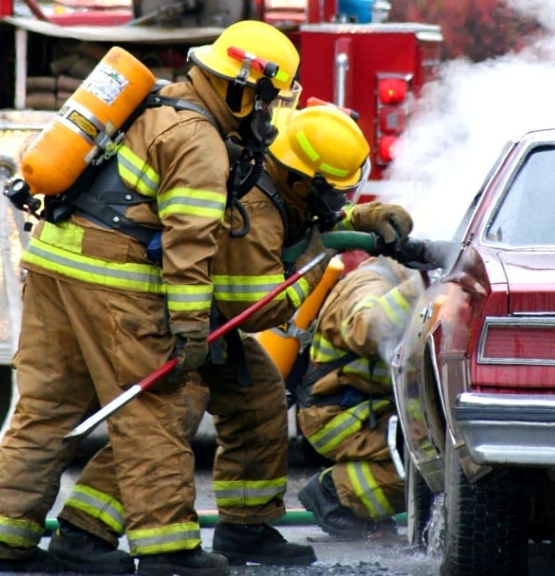 firefighters extinguishing car accident fire