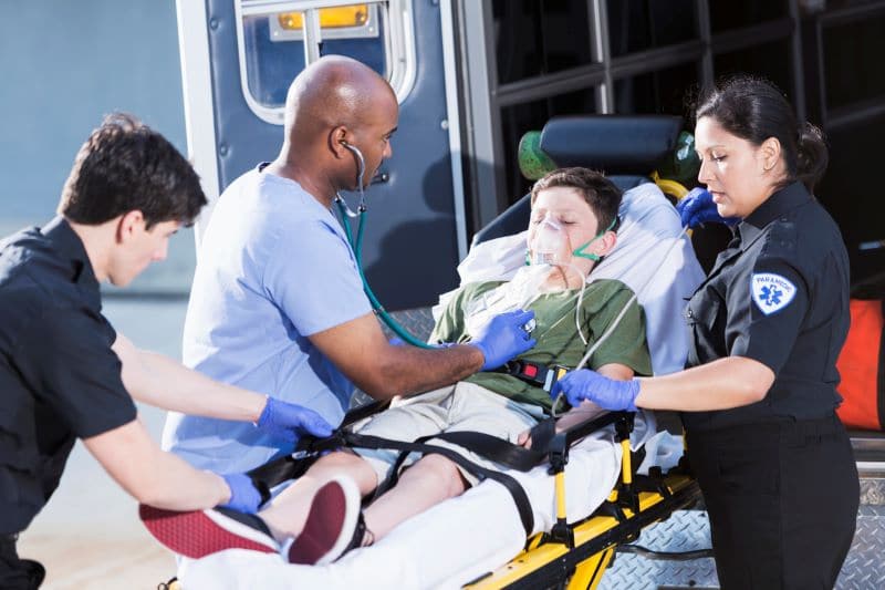 little boy getting medical attention after being injured in school bus accident