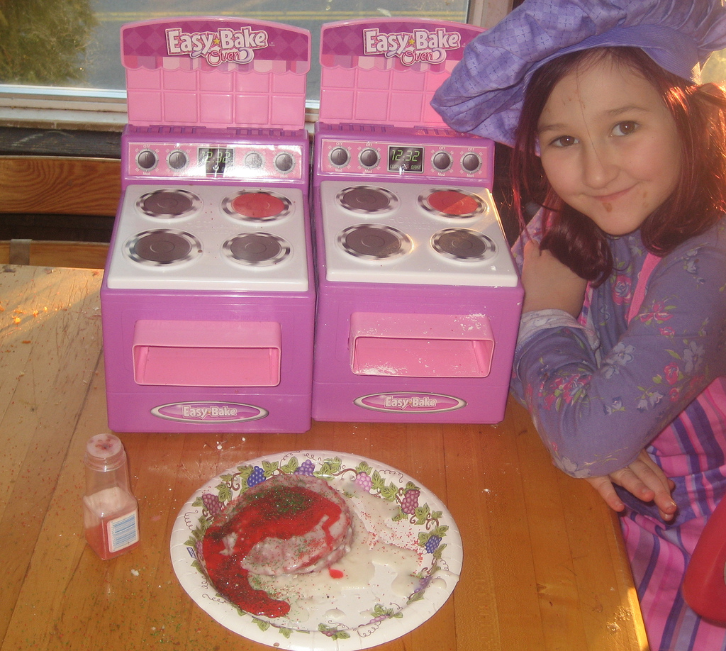 Little girl in chef hat with Easy Bake Oven